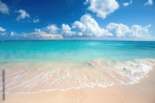 a sandy beach with blue water and white clouds