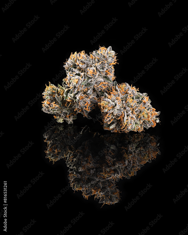 Grouped cannabis nug on black reflective surface Grouped cannabis nug on black reflective surface