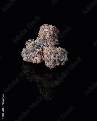Grouped cannabis nug on black reflective surface