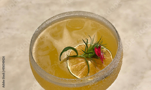 Hand-crafted cocktail decorated with a lemon slice and edible flower