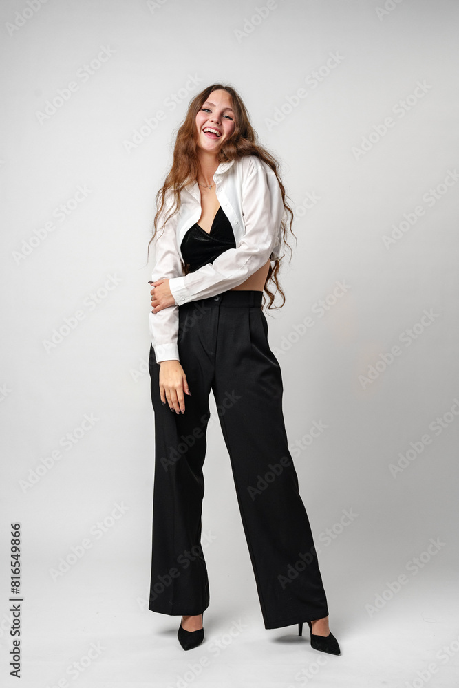 Joyful Young Woman in Elegant Attire Laughing Against a Grey Backdrop Joyful Young Woman in Elegant Attire Laughing Against a Grey Backdrop