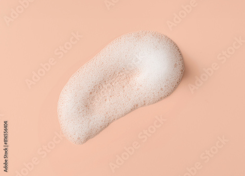 White skincare cleansing foam swatch on a pink background