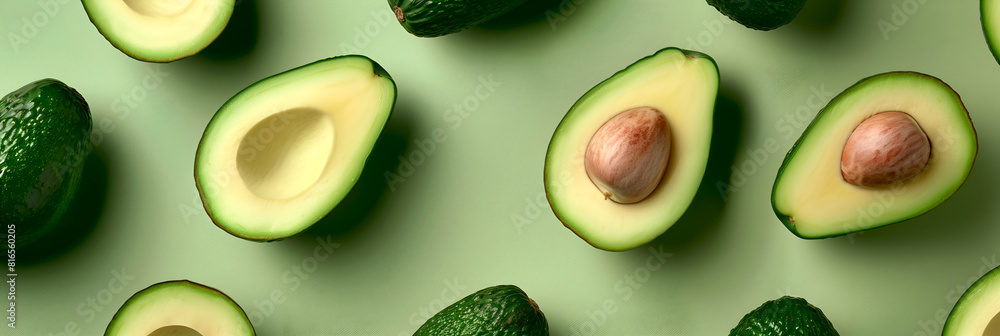 Avocado background with sliced avocados on green. Avocado halves with pits on light green background. Ripe avocados arranged neatly on soft green. Whole and sliced avocados with visible pits Avocado background with sliced avocados on green. Avocado halves with pits on light green background. Ripe avocados arranged neatly on soft green. Whole and sliced avocados with visible pits