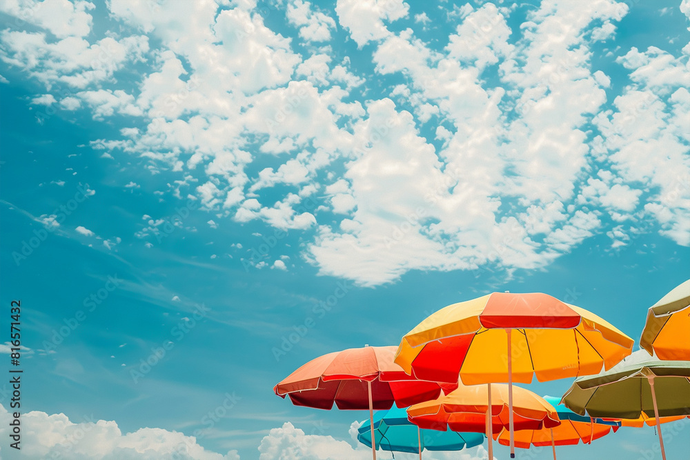 Colorful beach umbrellas against a blue cloudy sky Colorful beach umbrellas against a blue cloudy sky