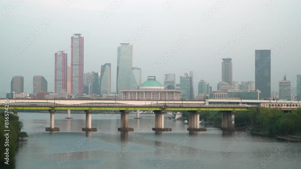 Cars Driving On Yanghwa Bridge Over Han River With Korean National Assembly And Yeouido Island Skyline In The Background In Seoul, South Korea. - wide shot Cars Driving On Yanghwa Bridge Over Han River With Korean National Assembly And Yeouido Island Skyline In The Background In Seoul, South Korea. - wide shot