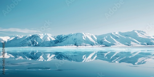 Photo of snow covered mountains reflecting in the water, clear blue sky © EMRAN