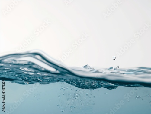 Close-up of a water surface with droplets falling, capturing the fluidity and purity of water. The image conveys a sense of freshness and tranquility.