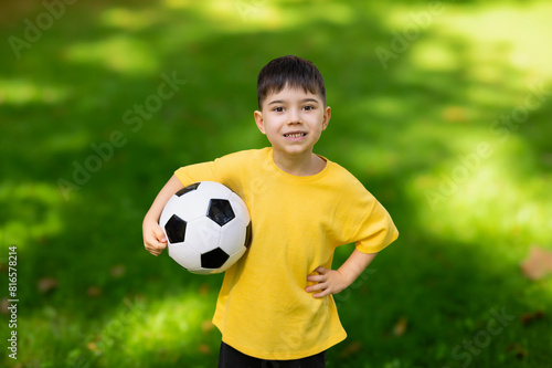boy kid playing football in park on grass.child with ball in hands lying on ground.siblings, brothers and father,dad and son,playing together. balloon under man arm.getting ready for championship © Alexandra