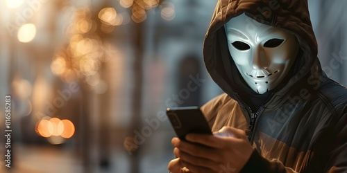 A hacker in a white mask steals data using a smartphone. Concept Cybersecurity, Data Breach, Hacker, White Mask, Smartphone