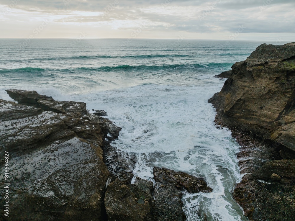 Waves washing over rock at sunset. Piha, Auckland, Auckland, New Zealand. Waves washing over rock at sunset. Piha, Auckland, Auckland, New Zealand.