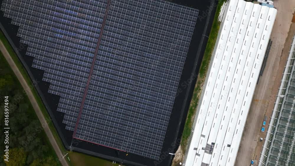 Solar panel farm generating energy for massive industrial greenhouses, aerial drone view