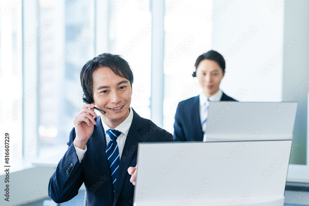 オフィスで働く日本人男性のオペレーター オフィスで働く日本人男性のオペレーター