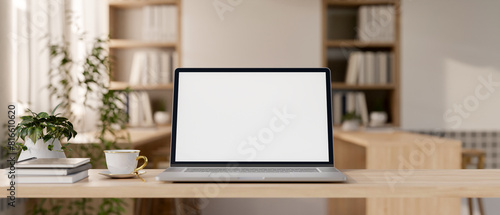 A laptop computer mockup on a wooden tabletop in a contemporary minimalist cafe co-working space.