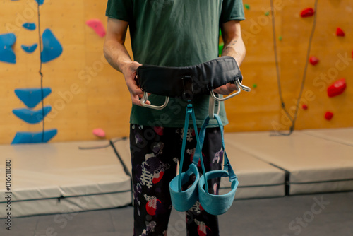 the climbing wall during the process putting on the belay the coach helps to secure everything correctly