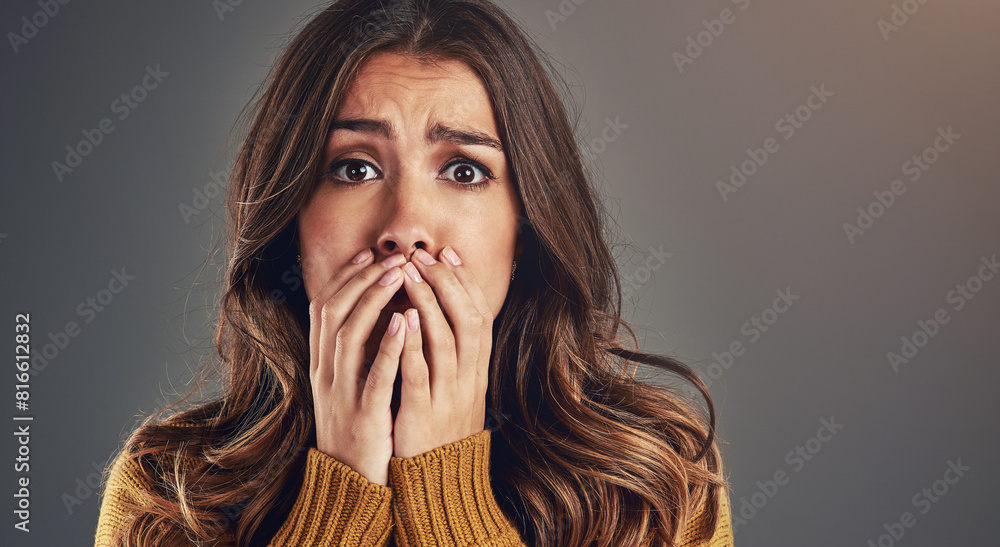 Portrait, scared and woman with fear, surprise and emotions with secret news on grey studio background. Face, person and model with reaction, shocked and cover mouth with anxiety and emoji of gossip Portrait, scared and woman with fear, surprise and emotions with secret news on grey studio background. Face, person and model with reaction, shocked and cover mouth with anxiety and emoji of gossip