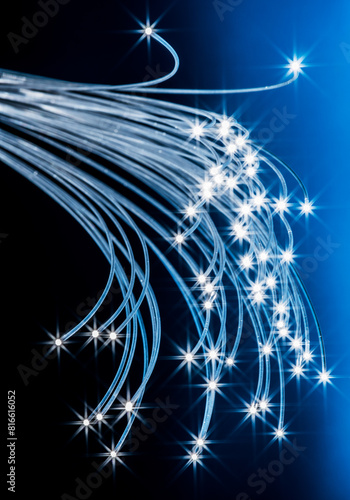 Bundle of optical fibers with lights in the ends. Blue background. © volff