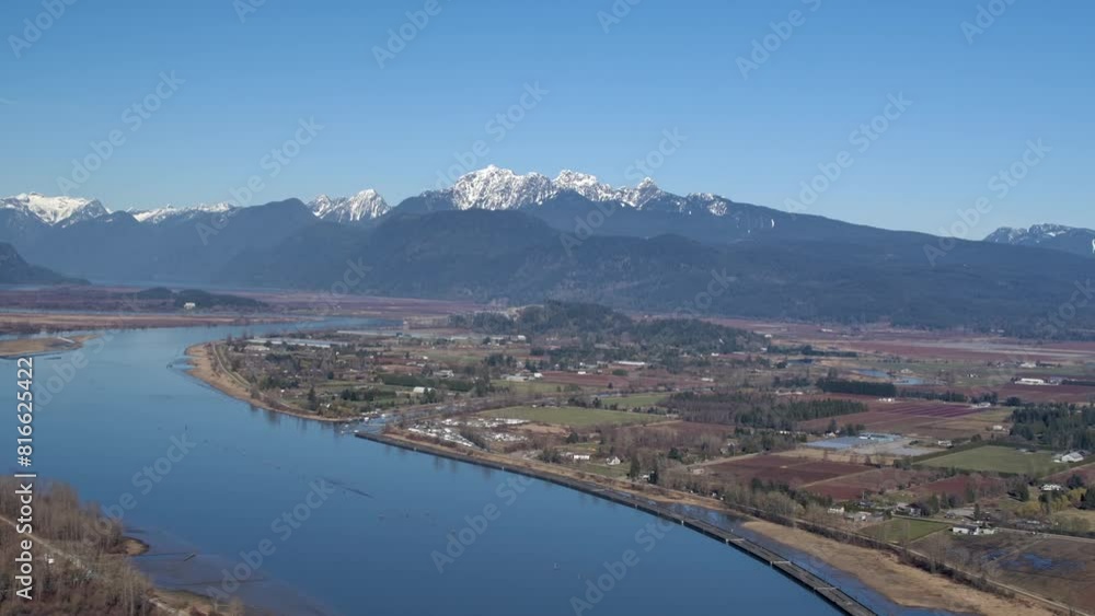 Broad River with Snow Capped Mountains in Distance - Sunny Day Aerial Broad River with Snow Capped Mountains in Distance - Sunny Day Aerial