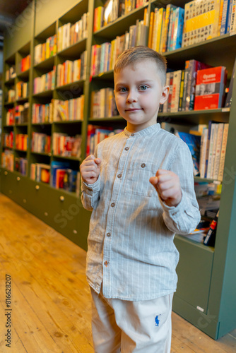 close-up in a bookstore a handsome boy stands smiling among the bookshelves a happy customer