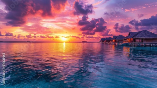 Sunset Over Ocean With Huts in Background