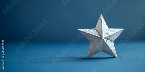 Silver origami star on a blue background, perfect for themes of craftsmanship and creativity.