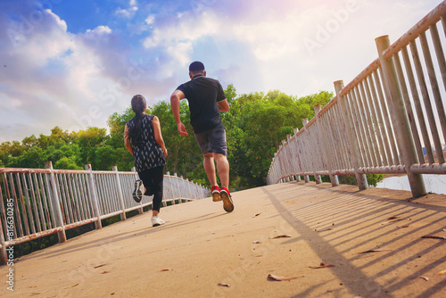 Couple running together on road across the bridge. Couple, fit runners fitness runners during outdoor workout	