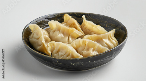 Plate with tasty dumplings on white background closeup
