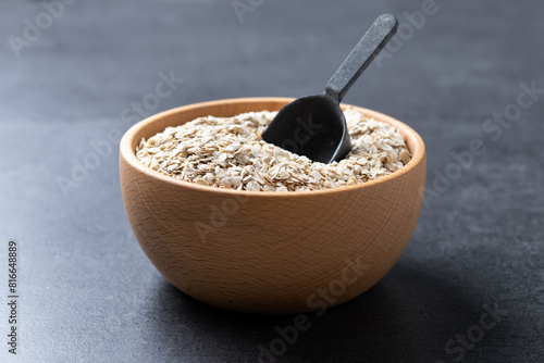 Rolled oats, healthy breakfast cereal oat flakes on black background photo