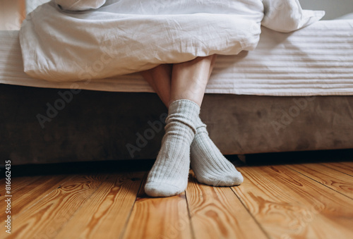 Feet in warm socks feet peeking out from under the blanket