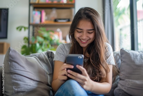 Happy Person Cell Phone. Teenage Hispanic Girl Playing Games on Smartphone at Home