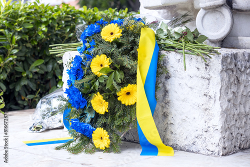Ukrainian commemorative grave wreath with Ukraine national flag and blue and yellow flowers