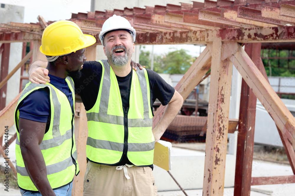 Happy harmony people at workplace, smiling white foreman and African engineer worker cuddle around necks at construction building site. Love and respect in differences of race skin color, diversity Happy harmony people at workplace, smiling white foreman and African engineer worker cuddle around necks at construction building site. Love and respect in differences of race skin color, diversity