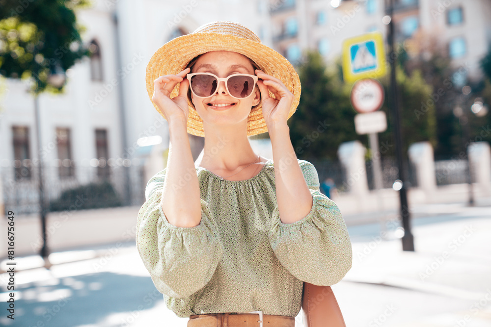 Young beautiful smiling brunette woman in trendy summer dress. Sexy carefree woman posing in street. Positive model outdoors at sunny day. Cheerful and happy. In hat and sunglasses Young beautiful smiling brunette woman in trendy summer dress. Sexy carefree woman posing in street. Positive model outdoors at sunny day. Cheerful and happy. In hat and sunglasses