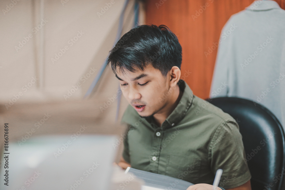 Asian person working on a computer at the office Asian person working on a computer at the office