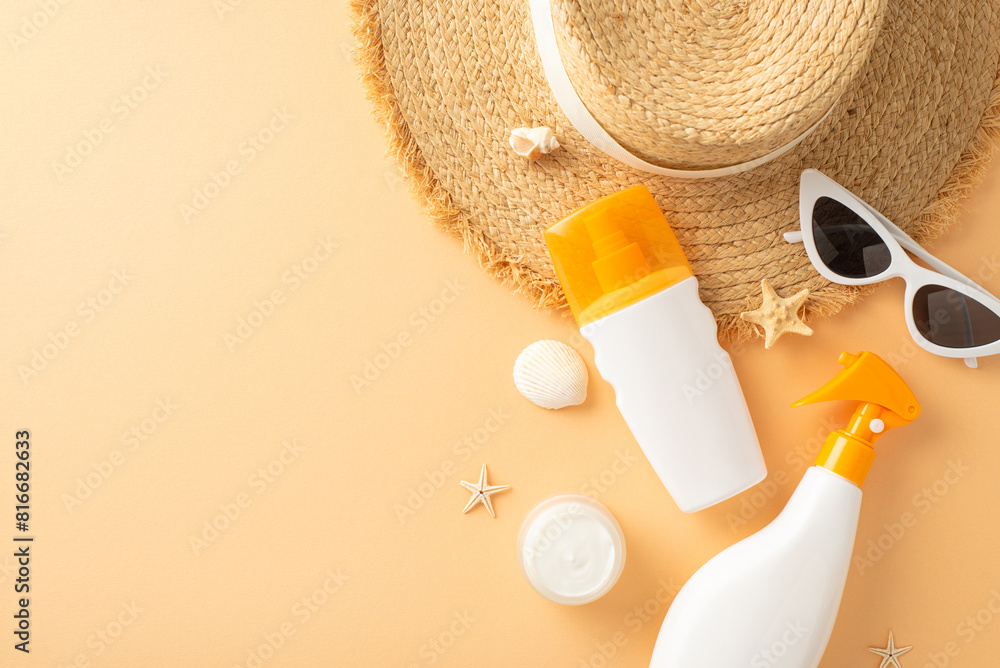 Top view of summer beach accessories arranged neatly on a beige surface, featuring sunscreen, a straw hat, sunglasses, and seashells Top view of summer beach accessories arranged neatly on a beige surface, featuring sunscreen, a straw hat, sunglasses, and seashells
