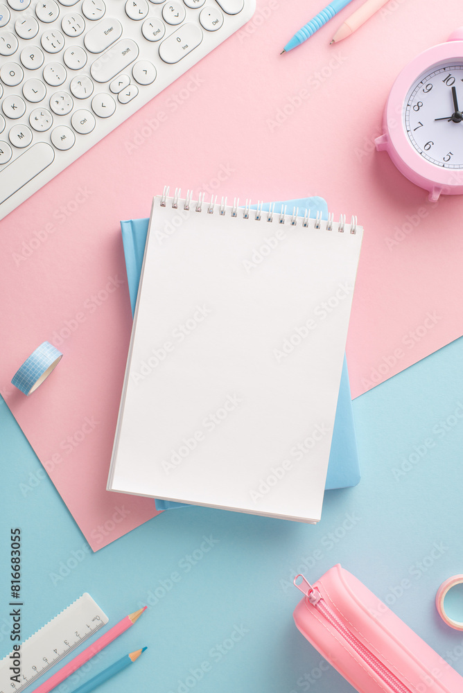 Top vertical view of an organized desk setup with pastel-colored workspace elements, featuring a blank notebook, keyboard, and modern accessories Top vertical view of an organized desk setup with pastel-colored workspace elements, featuring a blank notebook, keyboard, and modern accessories