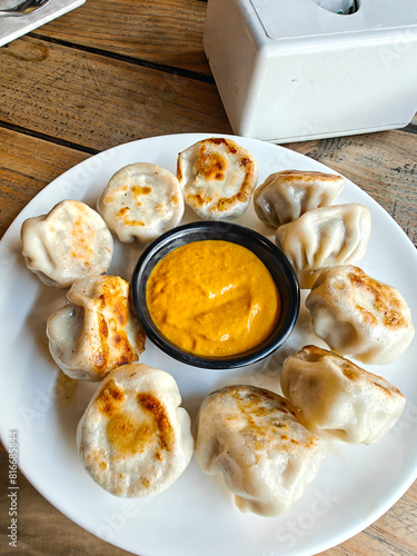 Close-up shot of fried Momo on a plate with sauce served at a cafe. Kathmandu