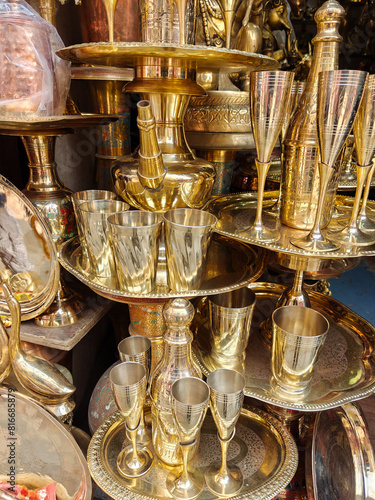 Large choice of shiny handmade brass tableware at an outdoor market in Kathmandu