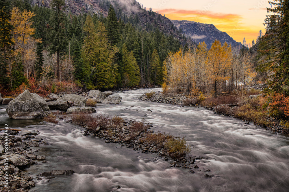 River winding through a forest in Washington State, USA, with fall foliage and rocky banks River winding through a forest in Washington State, USA, with fall foliage and rocky banks