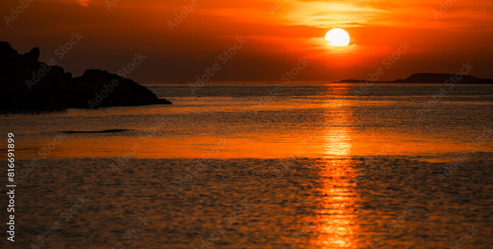 Stunning view of a serene sunset over the sea, illuminated by the golden glow in Lofoten, Norway Stunning view of a serene sunset over the sea, illuminated by the golden glow in Lofoten, Norway