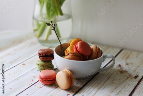 multi-colored macarons in a cup on the table 