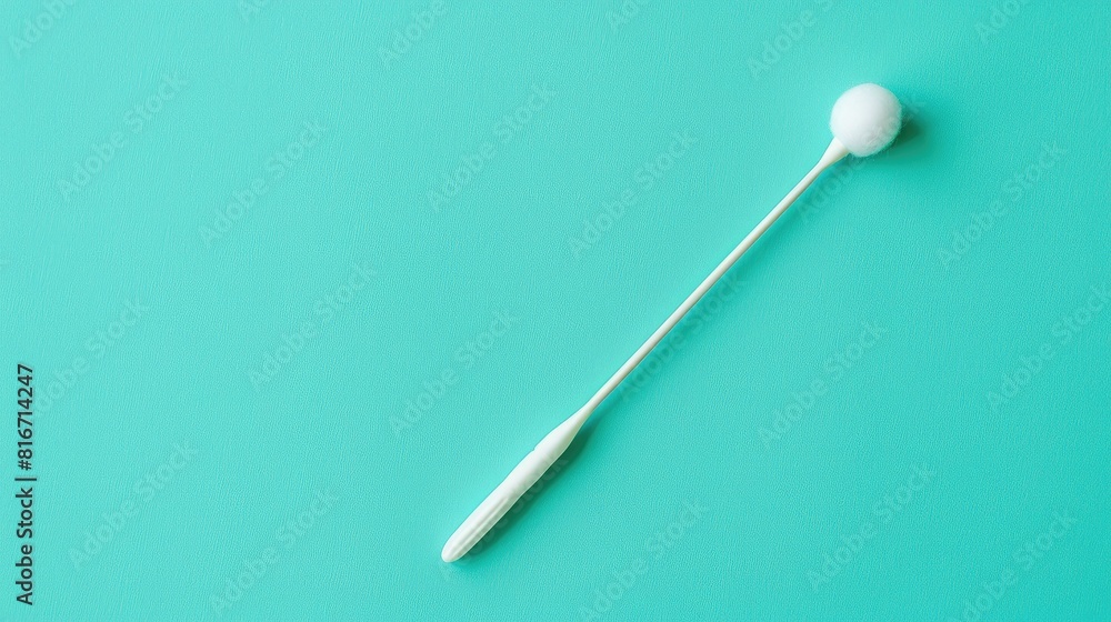 A cotton swab on a green backdrop for ear hygiene and personal care A cotton swab on a green backdrop for ear hygiene and personal care