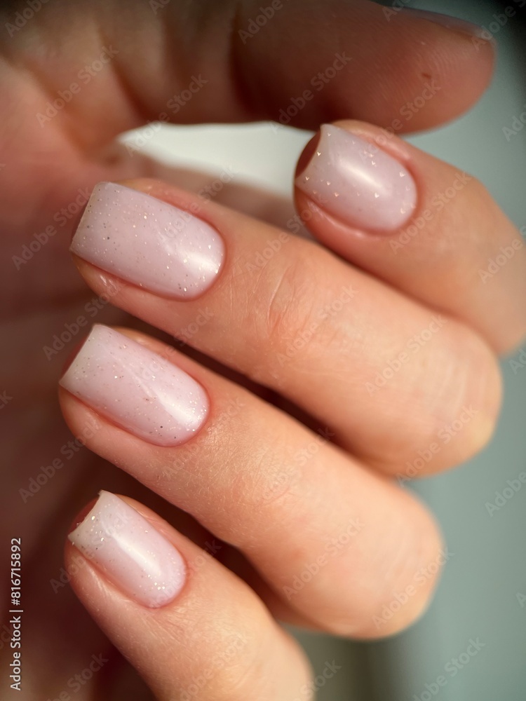Close-up of a female with carefully manicured pastel pink fingernails Close-up of a female with carefully manicured pastel pink fingernails