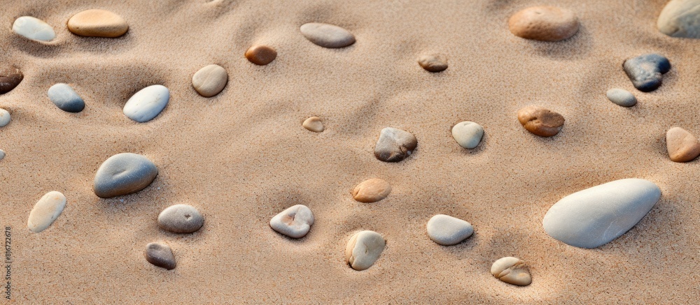 A copy space image of footprints formed by pebbles on a sandy beach