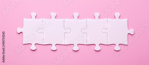 A top view of a white puzzle on a pink background There is a missing piece in the puzzle Copy space image