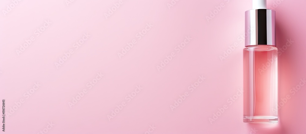 Top down view of a cosmetic serum placed on a pink background creating an ideal copy space image for text placement Top down view of a cosmetic serum placed on a pink background creating an ideal copy space image for text placement
