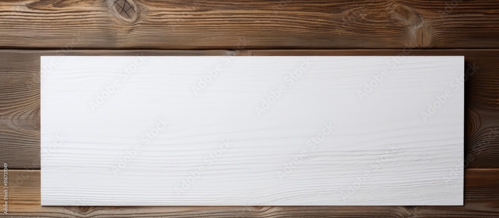 Wooden surface with a white paper providing empty space for images. with copy space image. Place for adding text or design