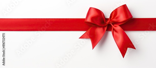 A shiny red silk ribbon on a white background creating a festive atmosphere The image is taken from a top down perspective It is a copy space image