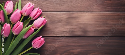 A Women s Day copy space image featuring elegant pink tulips arranged in a frame like shape against a wooden background