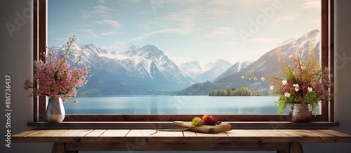 A sunny warm day creates a peaceful landscape with a retro brown window sill in the background The sill offers free space for personalized decoration and the scene showcases a spring lake and mountai photo