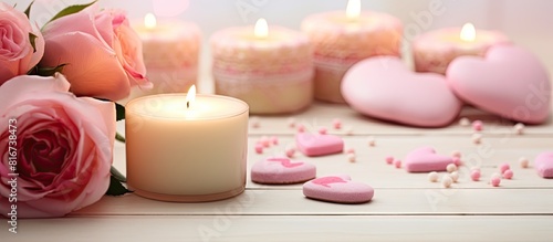 A white table with homemade heart shaped Valentine s Day cookies pink roses and a candle providing a copy space image